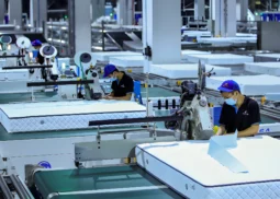 Opérateurs sur une ligne automatisée de fabrication de matelas dans une usine moderne, illustrant le pilotage de projets industriels par Bestlead, spécialiste du management de transition et de l’amélioration de la performance opérationnelle.