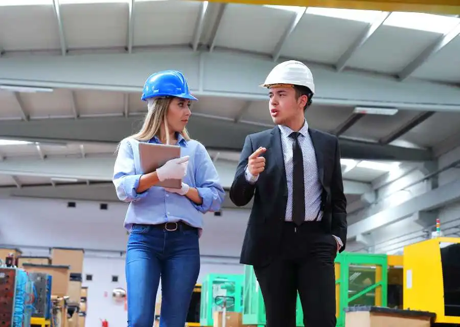 Manager de transition et employée marchant ensemble dans un atelier