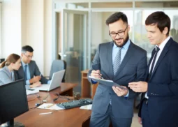 Managers en costumes travaillant en équipe autour d’un bureau, illustrant le management de transition, la direction de projet et l’accompagnement du changement en entreprise par Bestlead.